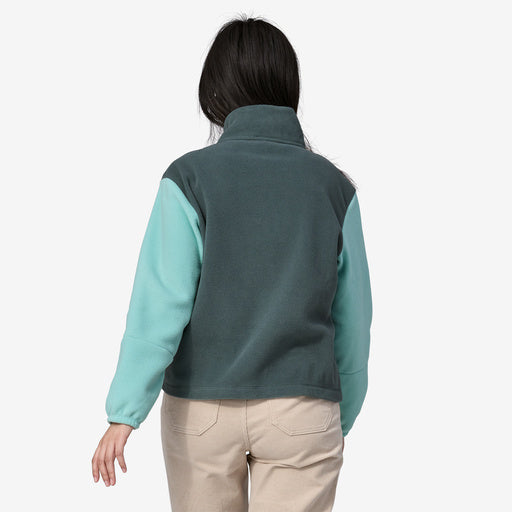 Back view of woman wearing 1/2 zip green fleece