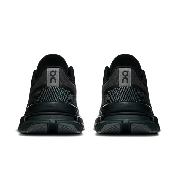 A pair of black On running shoes shown from the back, featuring a textured mesh upper, a gray heel tab with the On logo, and thick black midsoles, set against a plain white background.