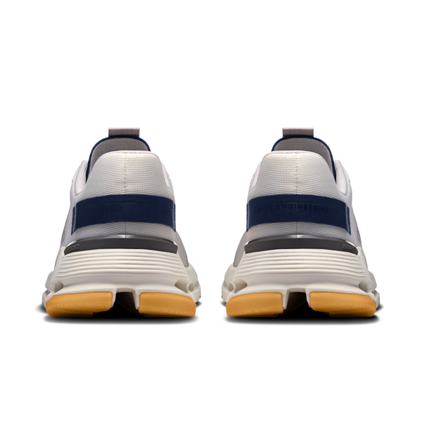 White athletic shoes with navy blue accents on a white background