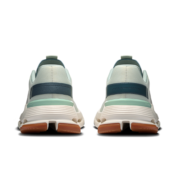Back view of white sneakers with a blue band and brown sole on a white background