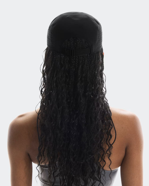 Person with long, dark hair styled in a ponytail against a white background