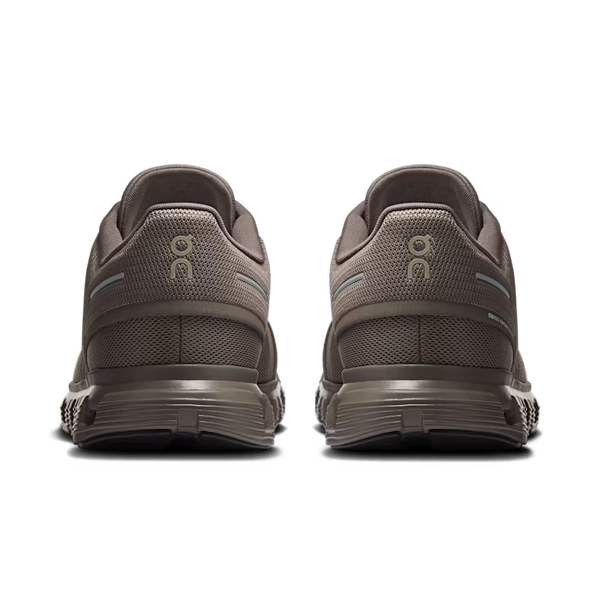 A pair of running shoes shown from the rear, featuring a textured taupe-brown mesh upper and a thick matching midsole, with a small light blue accent stripe on the heel.