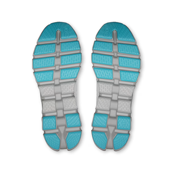 A pair of athletic shoe soles shown from the bottom, featuring a dual-tone design with bright turquoise blue textured sections and a light gray ribbed midsole.
