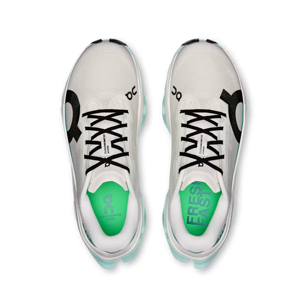 A pair of On running shoes shown from a top-down view, featuring a white mesh upper with black accents, black laces, and a bright green tongue.