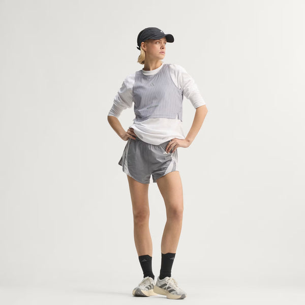 A women tanding wearing adidas running shoes and cloting that matches.