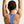 Person wearing a blue sports bra with arms raised against a light background