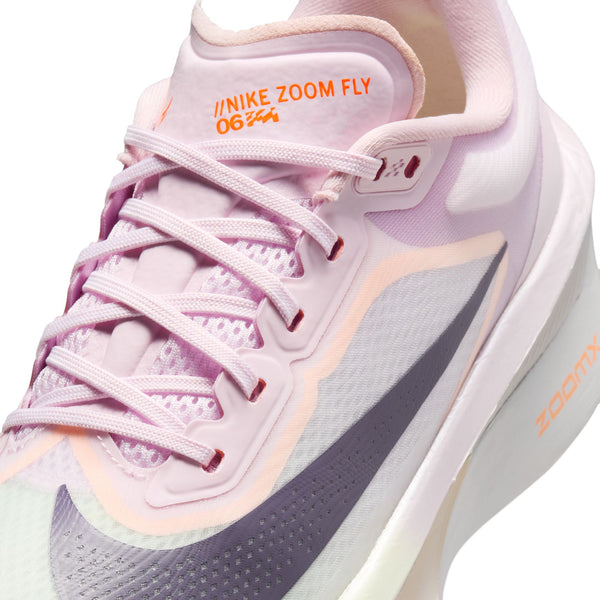 White running shoe with purple and green accents on a white background