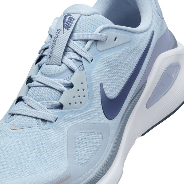 Close up of a light blue running shoe with Nike logo on a white background.