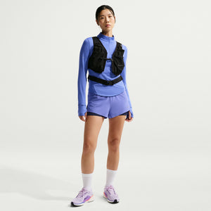Person wearing a blue athletic outfit with a black vest on a white background