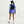 Person wearing a blue athletic outfit with a black backpack on a white background