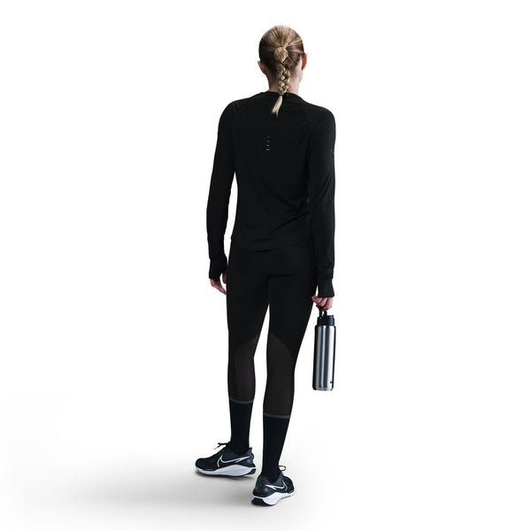 Person wearing a black athletic outfit holding a water bottle on a white background