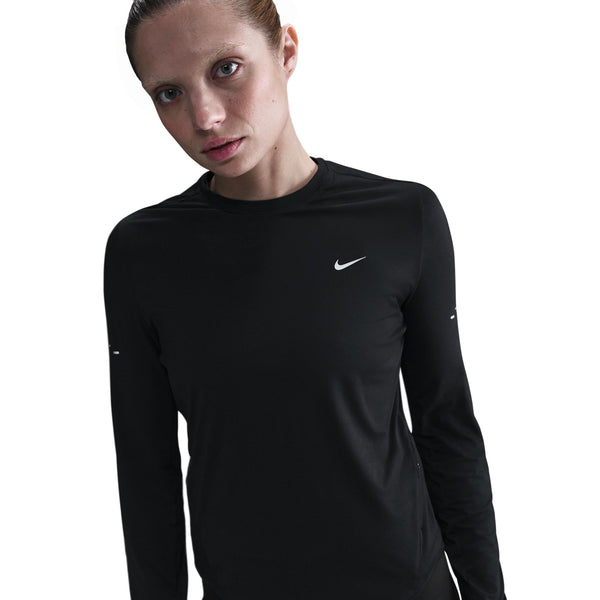 Person wearing a black long-sleeve athletic shirt with a Nike logo on a white background