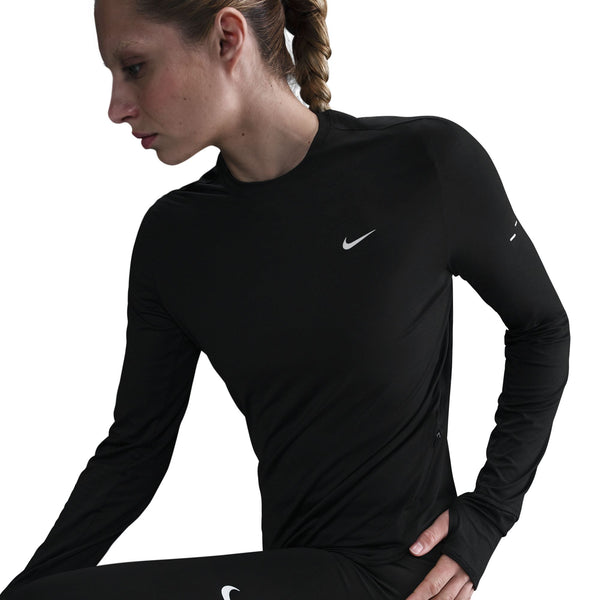 Woman wearing a black Nike long-sleeve athletic shirt on a white background