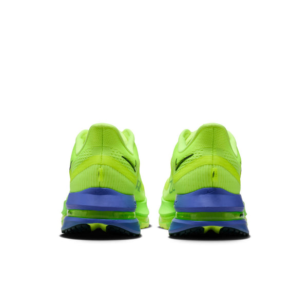 Pair of neon green running shoes with blue soles on a white background