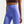 Person wearing blue leggings and a brown sports bra on a light gray background