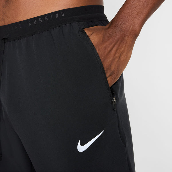 Black Nike running shorts with a white logo on a neutral background