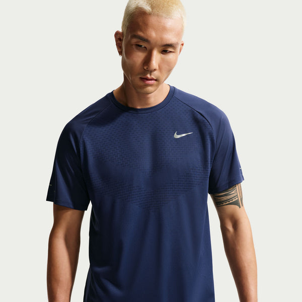 Man wearing a navy blue Nike t-shirt on a light gray background