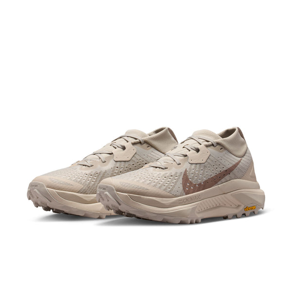 Pair of beige running shoes on a white background