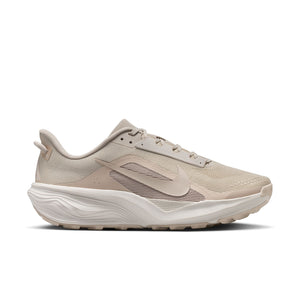 Beige Nike trail running shoe with a white sole on a white background