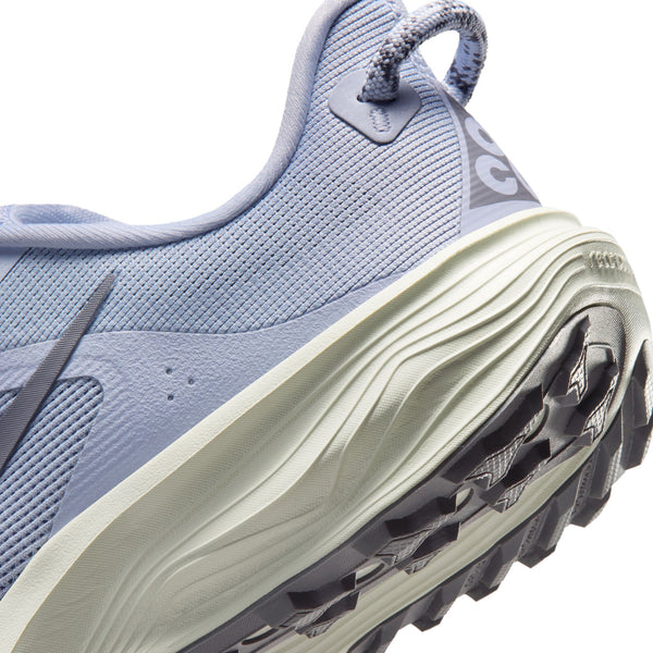 Close-up of a blue athletic shoe with a detailed sole on a white background