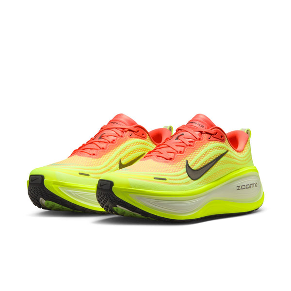 Pair of neon yellow and red running shoes with Nike logo on a white background.