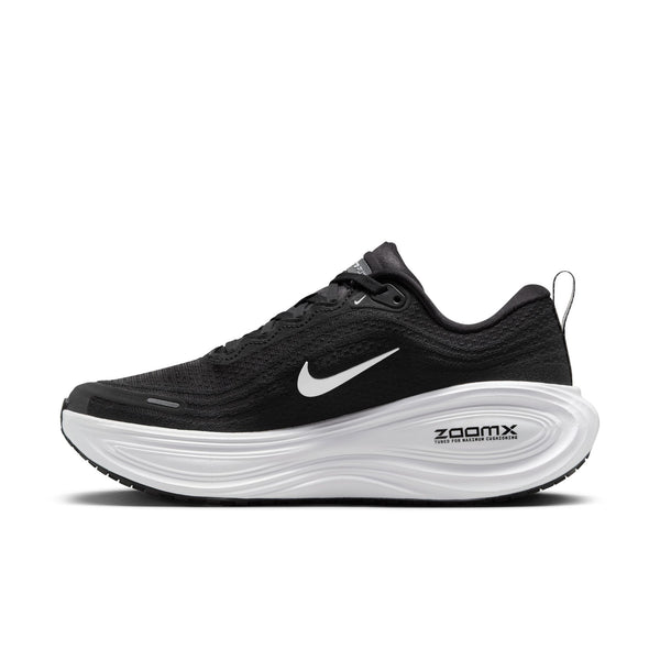 The medial side of a Nike black running shoe with white sole and swoosh in the middle of the shoe.