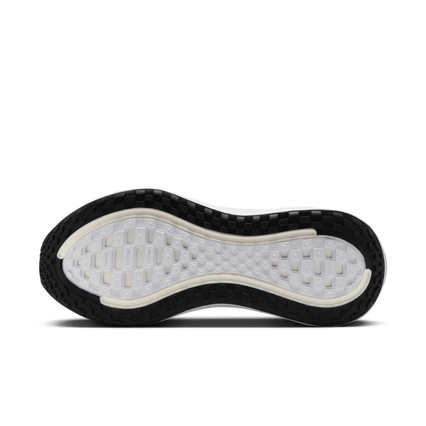 Close-up of a Nike running shoe sole with a white tread pattern that is surrounded by black treads.