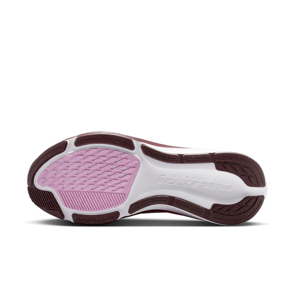 Sole of a shoe with pink cushioning and brown accents on a white background