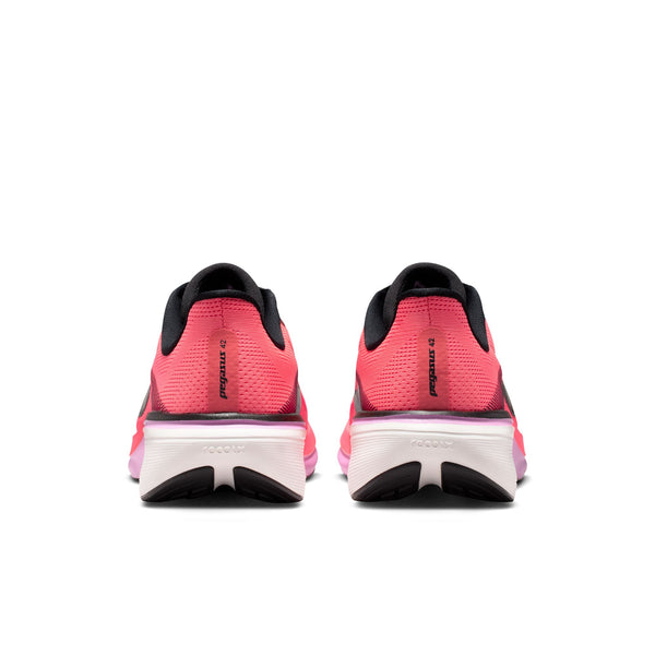 The focus is on the heel area of these Pegasus 42 pink running shoes with black soles on a white background