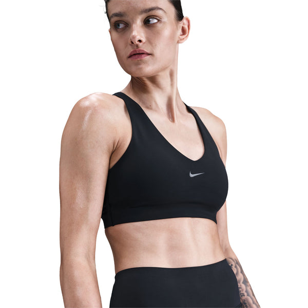 Woman wearing a black sports bra with Nike logo on a white background