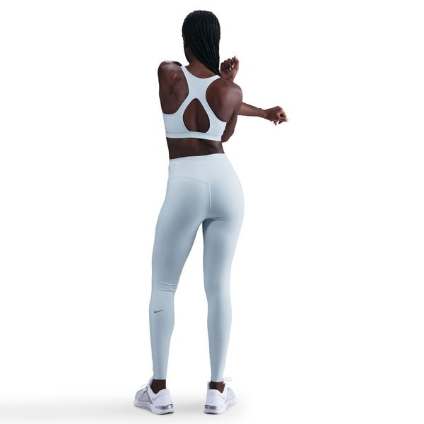 Person wearing a sports bra and leggings on a white background