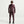 Person wearing a maroon tracksuit and headphones on a white background