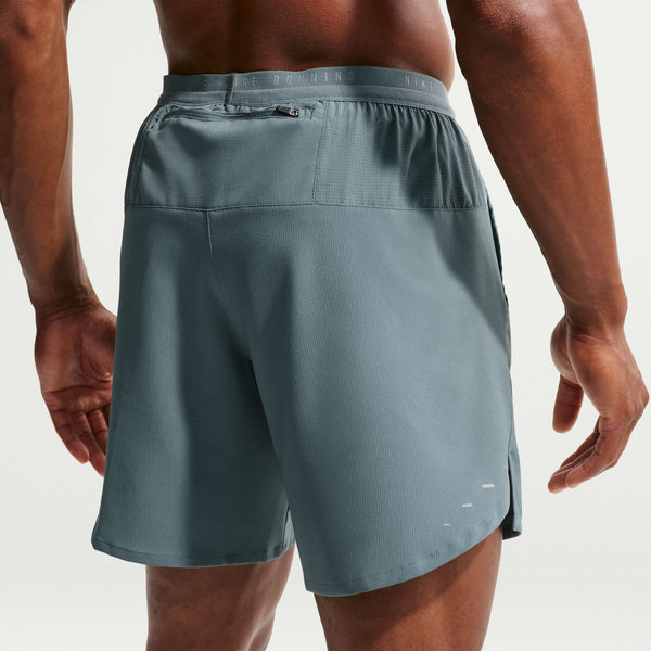 Person wearing a pair of gray athletic shorts on a plain background