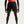 Person wearing black athletic shorts with a Nike logo on a light gray background