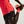 Person wearing red athletic shirt and black shorts with Nike logo, holding a colorful running shoe.