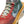 Close-up of a colorful sneaker with a prominent brand logo on a white background.