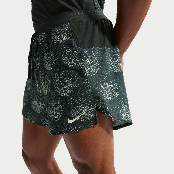 Black athletic shorts with a pattern and Nike logo on a neutral background