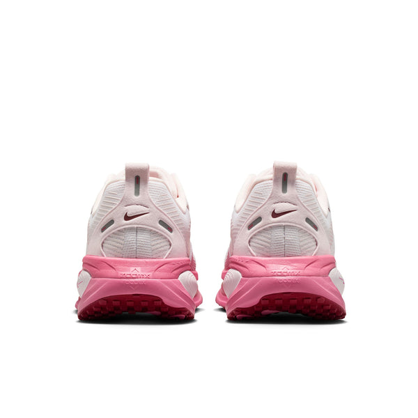 Close up on the heels of these Nike Pink and white sneakers with Nike logo on a white background