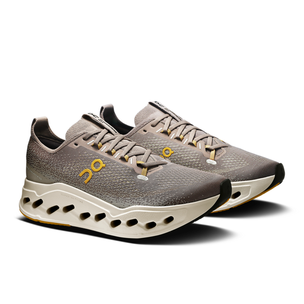 Pair of gray sneakers with a white sole on a white background.