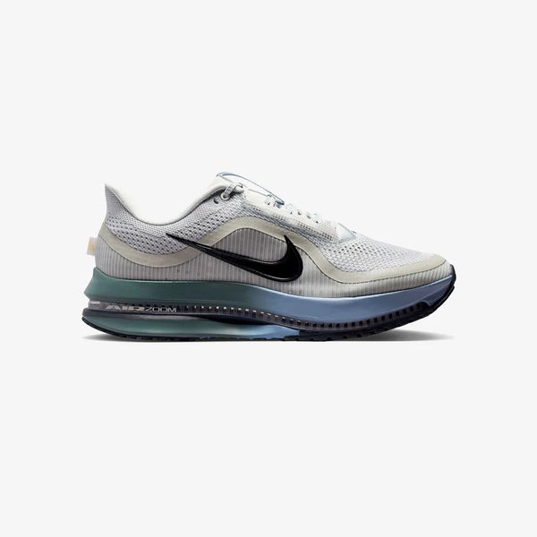 Grey, green, and blue running shoe on a white background