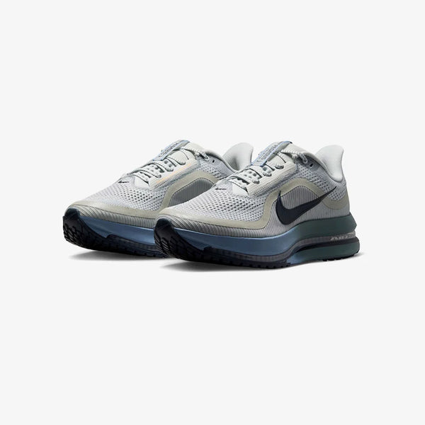 Grey, green, and blue running shoe on a white background