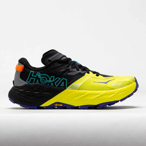 A Hoka trail running shoe in black and neon yellow, featuring a bright yellow midsole, teal Hoka branding on the side, and a small orange accent near the heel, set against a light gray studio background.
