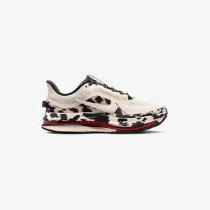 Cow print and red running shoe on a white background