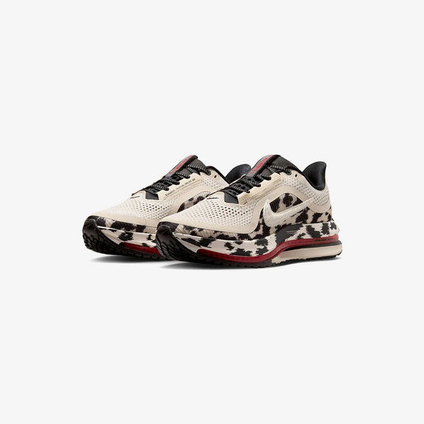 Cow print and red running shoe on a white background