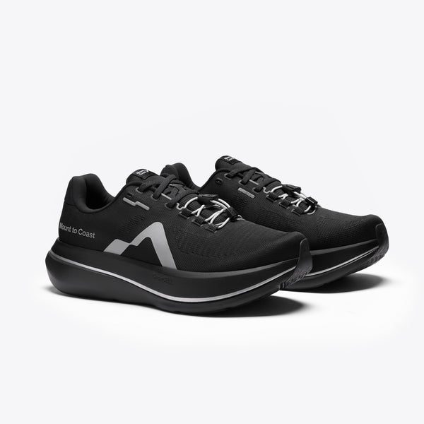 A black Mount to Coast running shoe with a thick black and silver platform sole.