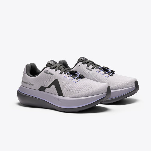 A light gray and purple running shoe with a dark gray sole and logo, featuring the text 'Mount to Coast' on the side