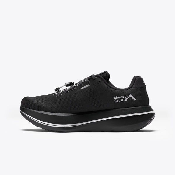 A black Mount to Coast running shoe with a thick black and silver platform sole.