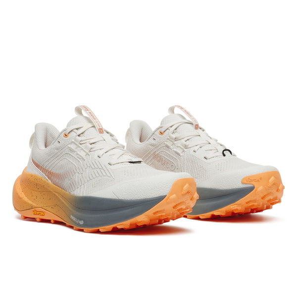 White running shoes with orange soles on a white background