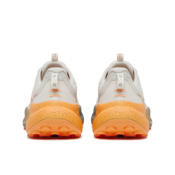 Pair of sneakers with orange soles on a white background