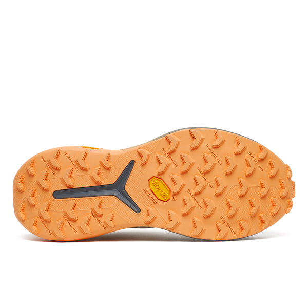 Orange sole of a shoe with tread pattern on a white background